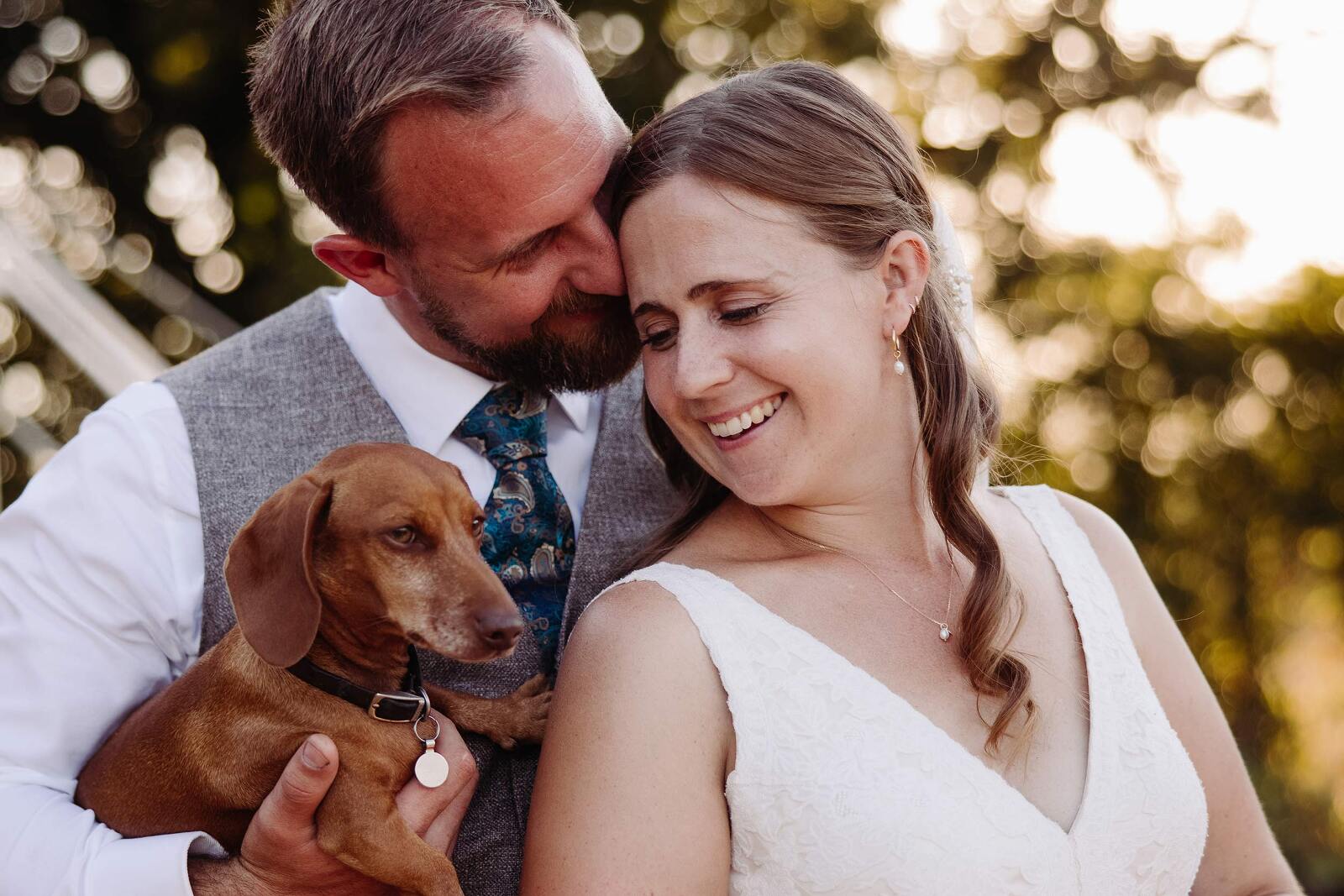 bride and groom moment with their sausage dog